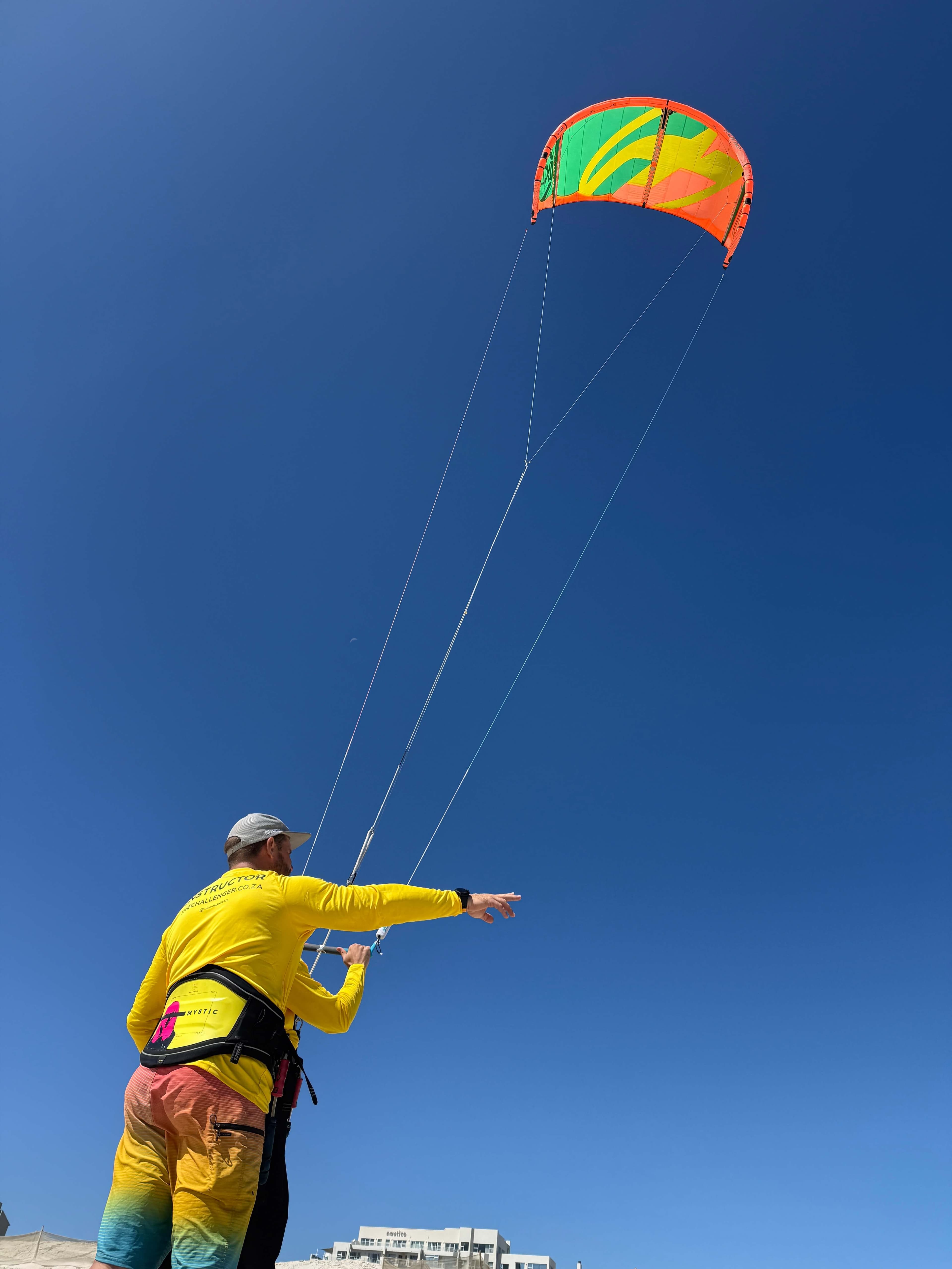 Instructor demonstrating kite flying against blue sky