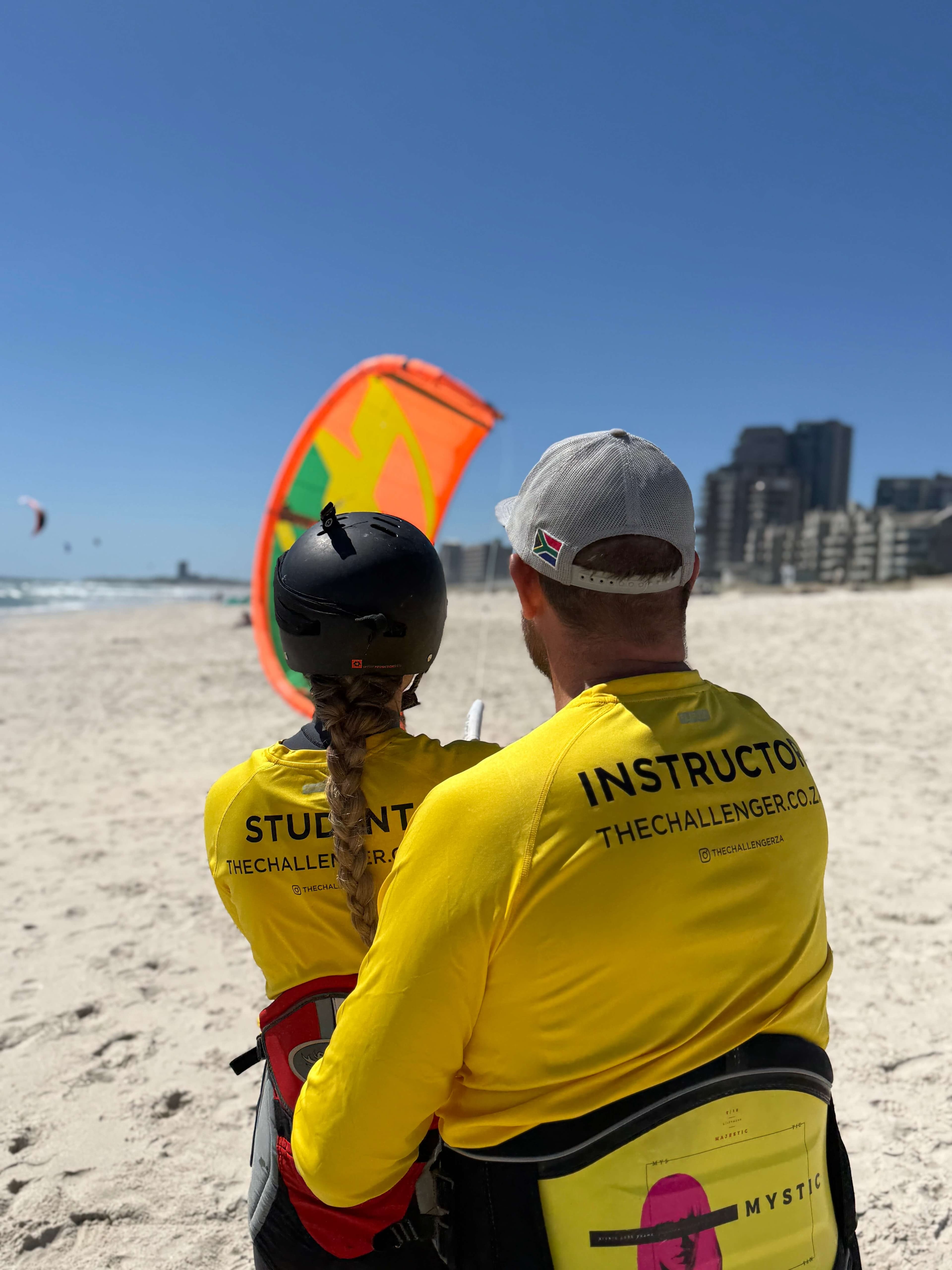 Instructor and student watching kite on the beach