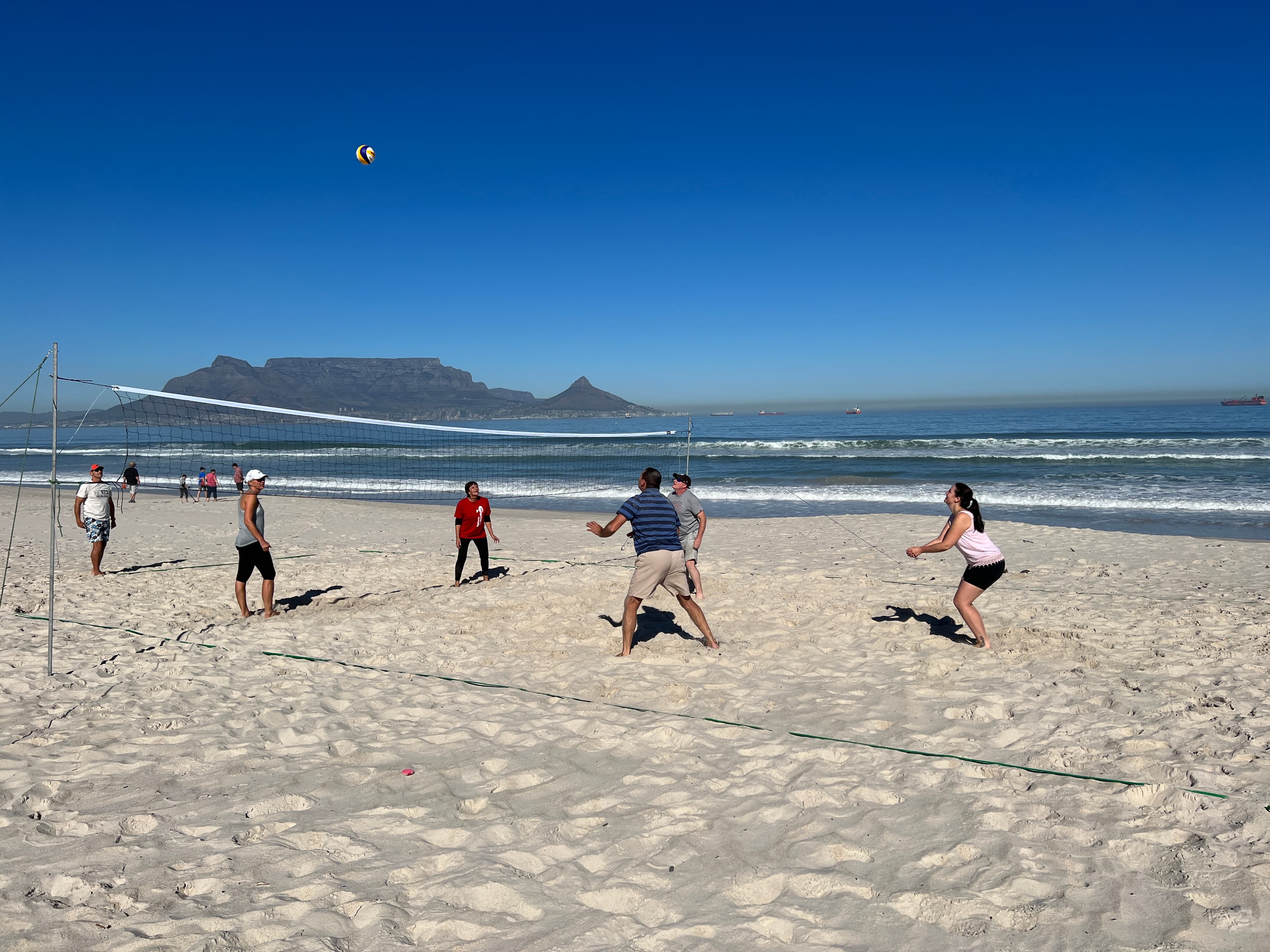 Beach volleyball group at Blouberg with Table Mountain view